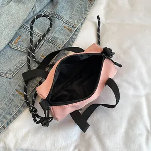 Pink sporty mini cylinder crossbody bag with black zipper and rope shoulder strap