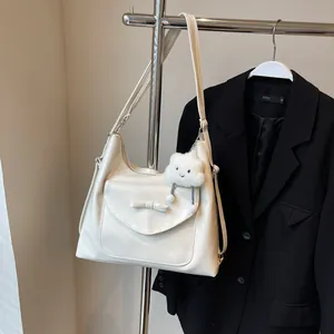 Detailopname van de grote crème draagtas met strikdetail en wolk pluche hanger