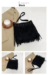 Detail of black faux suede tassel handbag featuring silver eyelets and adjustable strap