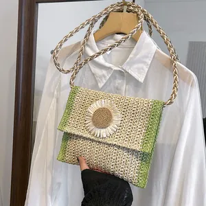 Close-up of a woven straw crossbody bag featuring a 3D daisy flower and thick strap