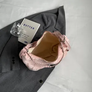Pink cloud-textured tote bag with silver chain strap on a stylish gray blazer