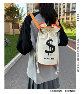 Outdoor shot of canvas drawstring bucket bag with orange contrast straps and bold logo