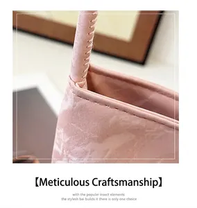 Vue macro d'un sac à main en cuir rose montrant les coutures et la finition soignée