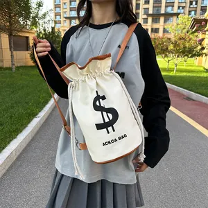 Chic canvas drawstring bucket bag in cream with brown leather trim and dollar sign print