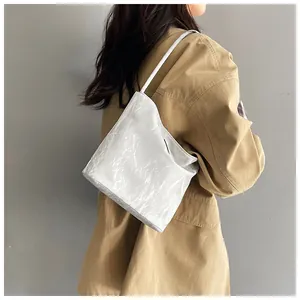 Gros plan sur la texture froissée blanche du sac à bandoulière minimaliste pour femme