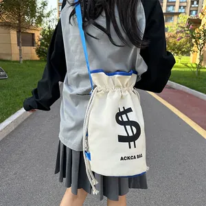 Detail of canvas bucket bag with dollar sign print and blue trim for streetwear style