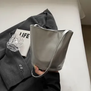 Close-up of a metallic silver bucket bag with Fashion & Bag logo on a textured blazer