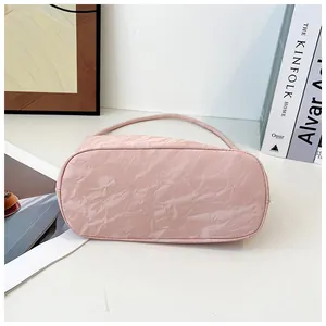Vue détaillée de la base du sac à main plissé rose montrant le cuir synthétique texturé