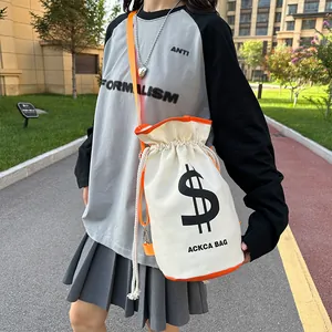 Detail of canvas bucket bag with orange straps and dollar sign logo in street style