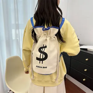 Detail of minimalist cream canvas bucket bag with dollar sign print and blue trim