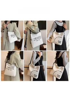 Dettaglio della borsa tote in tela bianca minimalista con stampa di lettere e tracolle sottili