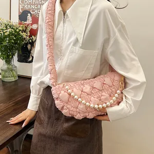Detail of pink quilted shoulder bag with cloud texture and elegant pearl chain strap