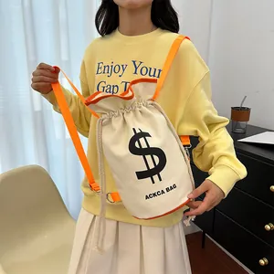 Detail of canvas drawstring bucket bag featuring orange straps and black graphic print