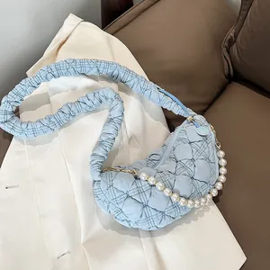 Detailed view of light blue quilted cloud bag with elegant pearl chain and ruched strap
