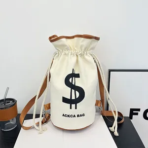 Detail of cream canvas bucket bag with brown leather trim and drawstring closure