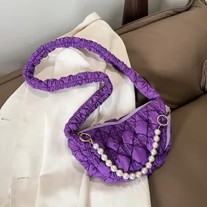 Macro detail of purple pleated cloud bag featuring elegant white pearl chain and metal zipper
