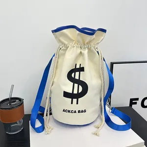 Detail of canvas bucket bag with blue trim, drawstring closure and logo print
