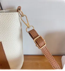 Détails de la quincaillerie dorée brillante sur un sac bandoulière en cuir grainé blanc