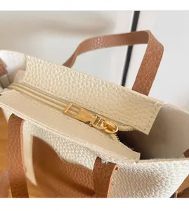 Détail de la fermeture éclair en métal doré sur le sac de téléphone bicolore texturé