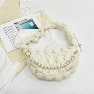 Detail of cream white pleated cloud bag with oversized pearl chain and scrunchie strap