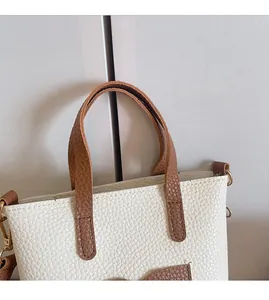Détail du mini sac de téléphone en cuir PU crème avec poignées brunes et crochets dorés