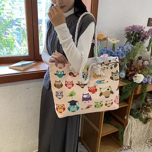 Detail of canvas tote bag showing colorful owl print and thick cotton rope shoulder strap