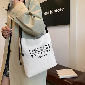 Borsa tote in tela minimalista con stampa alfabeto nero e tracolla in pelle annodata