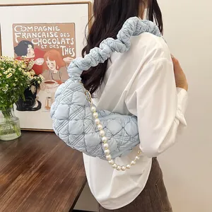 Light blue quilted cloud bag with pearl chain shown as a shoulder underarm bag