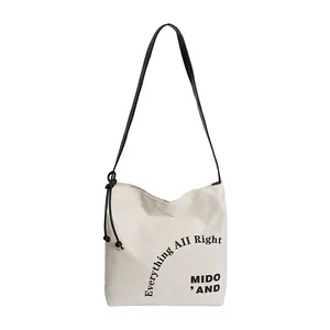 Borsa tote minimalista in tela con stampa e tracolla nera dal design essenziale