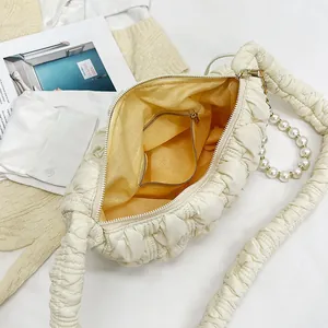 Chic off-white pleated cloud bag with pearl strap and bright yellow lining