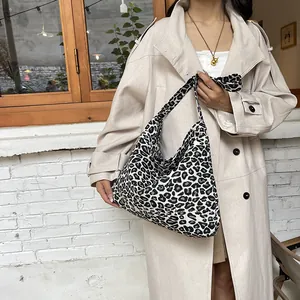Chic black and white leopard print canvas hobo bag styled on a beige trench coat