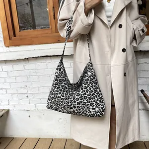Chic black and white leopard print large canvas hobo bag worn with a stylish trench coat