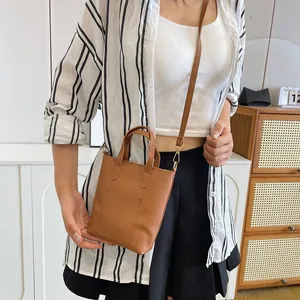 Petit sac bandoulière marron en cuir grainé pour femme avec lettrage embossé chic