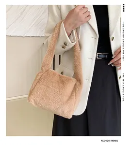 Detail of light brown plush shoulder bag worn by model with textured faux fur finish