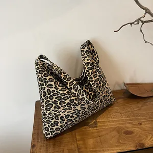 Close-up of leopard print canvas tote bag on a wooden table with natural lighting