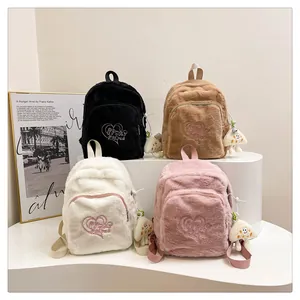 Detail view of plush mini backpacks in four colors with heart embroidery and mushroom charms