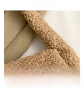 Close-up detail of plush lamb wool fabric and handle attachment in khaki faux fur bag