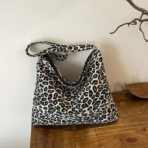 Detailed view of large black and white leopard print canvas tote bag on wood surface