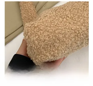 Macro detail of soft khaki faux shearling fabric texture on a trendy shoulder bag