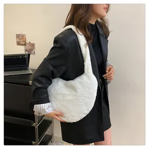 Sac fourre-tout en peluche blanche en forme de cœur porté avec une tenue noire