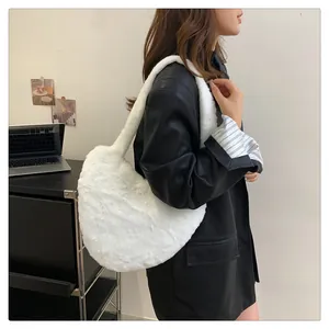 Detailansicht der weißen Plüsch-Hobo-Tasche mit weicher Textur am Modell getragen