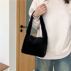 Detail shot of black faux fur shoulder bag showing thick plush texture and soft strap