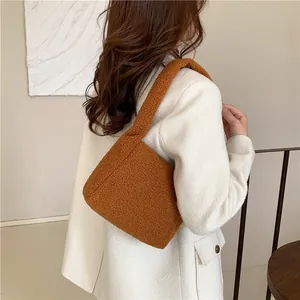 Detail of caramel teddy faux fur shoulder bag texture with soft plush curly grain material