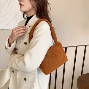Close-up of fluffy brown lamb wool shoulder bag with plush texture on a model