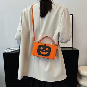 Λεπτομέρεια της τσάντας χιαστί με κολοκύθα Halloween φορεμένη από μοντέλο με λευκό σακάκι