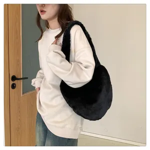 Nahaufnahme der weichen schwarzen Kunstfell-Textur und des breiten Trägers der Wintertasche