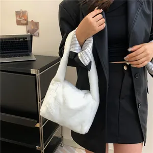 Detailed view of plush white faux fur shoulder bag worn with a black leather jacket