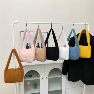 Fuzzy faux lamb wool shoulder bags in multiple colors hanging on a white rack