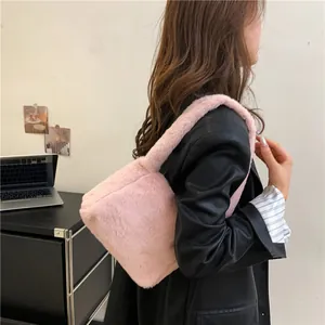 Detail of pink faux fur shoulder bag texture showing soft fluffy material on model