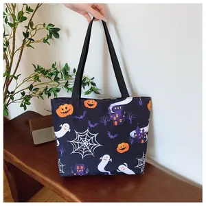 Detail of Halloween tote bag with pumpkin, ghost, and castle prints on black fabric